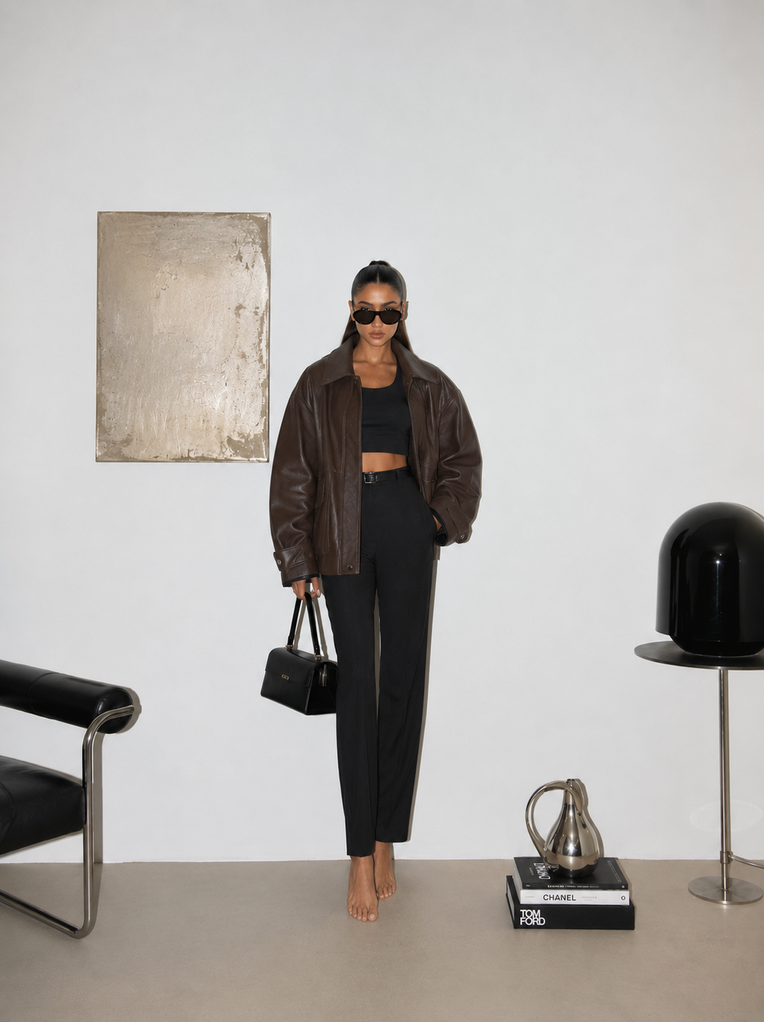 Woman in an oversized leather jacket in a styled interior