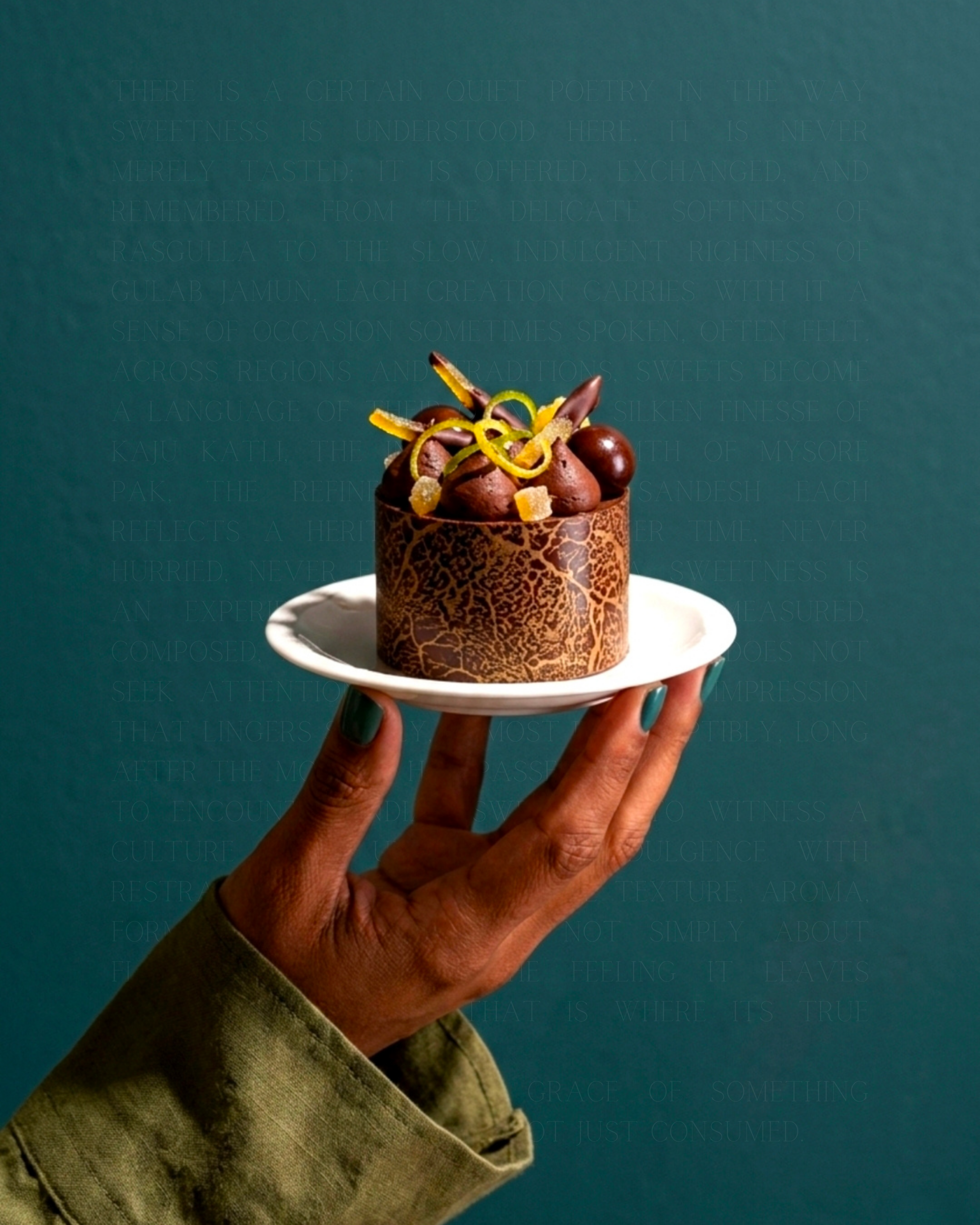 Hand holding a chocolate entremet on teal